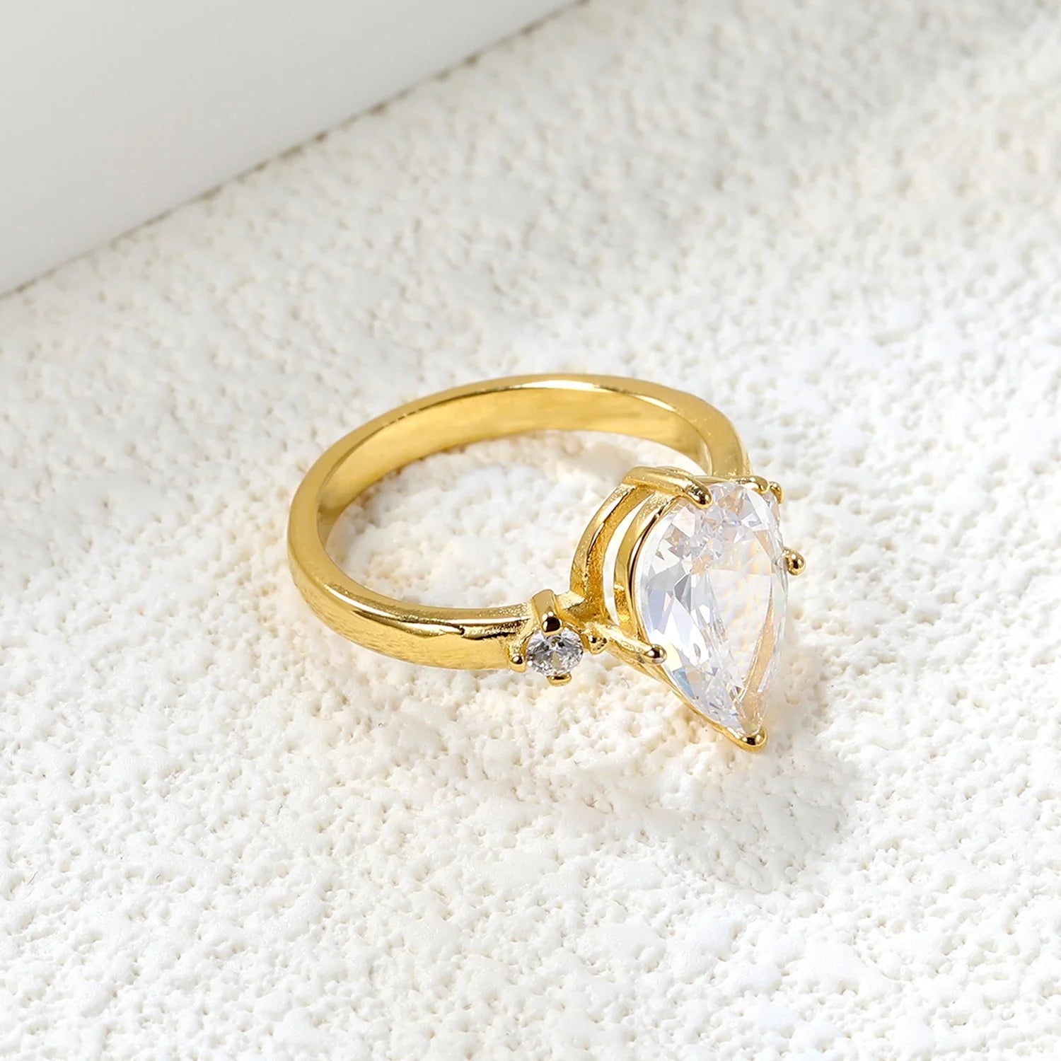 Con un grande diamante a goccia e due piccoli anelli di diamanti