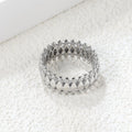 Anello composto da una pluralità di forme a diamante combinate e circondate da un anello protettivo.