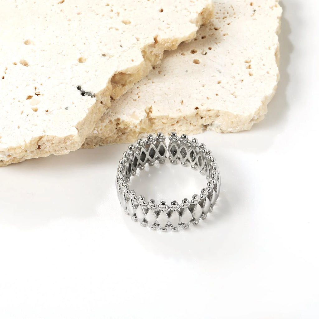 Anello composto da una pluralità di forme a diamante combinate e circondate da un anello protettivo.