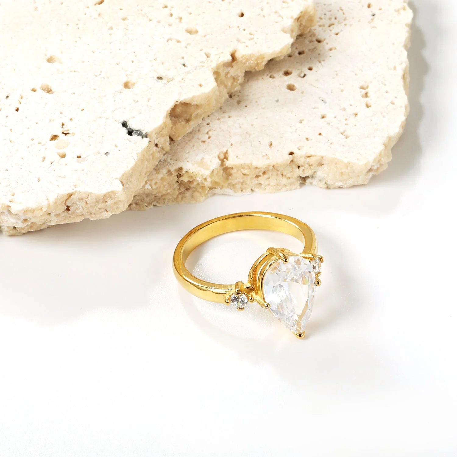 Con un grande diamante a goccia e due piccoli anelli di diamanti