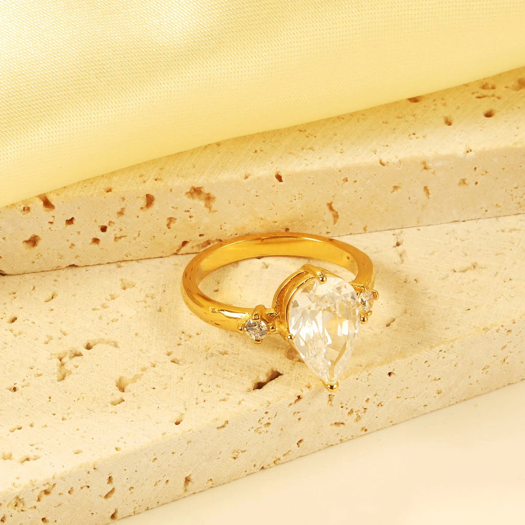 Con un grande diamante a goccia e due piccoli anelli di diamanti