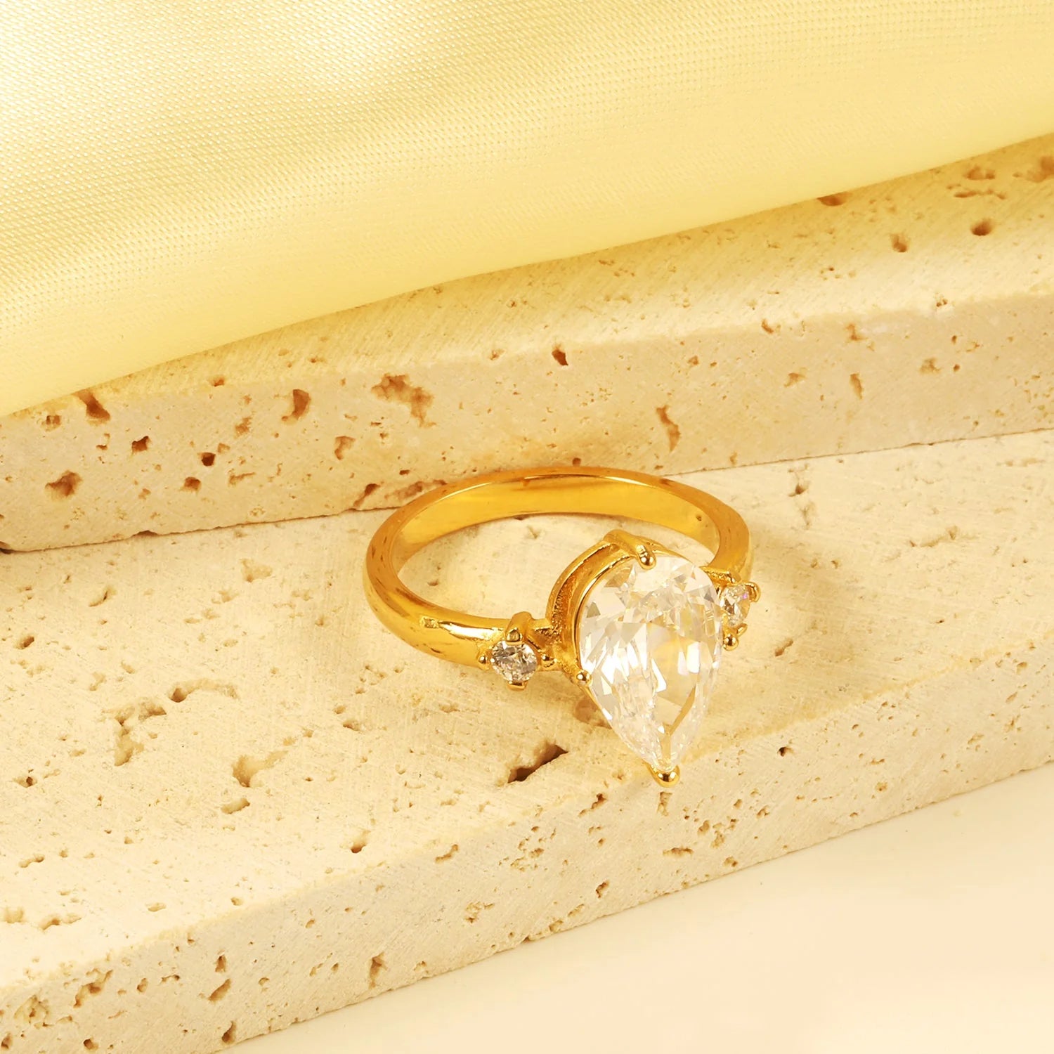 Con un grande diamante a goccia e due piccoli anelli di diamanti