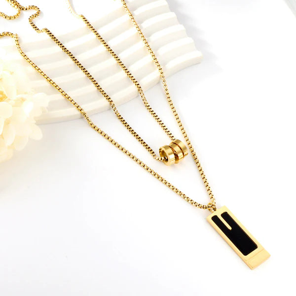 Collana a doppia catena con tre ciondoli rotondi cavi e ciondolo rettangolare con goccia d'olio nera.